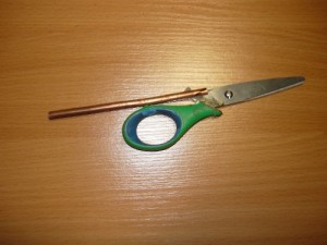 Примерка распиленного медного стержня на ножницах